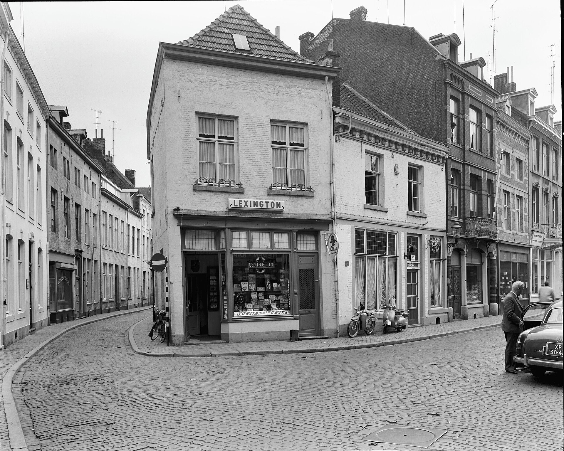 Sigarenwinkel op een straathoek in Maastricht, 1962, met een etalage vol dozen en een scooter voor de deur